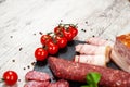 Smoked sausage, meat, bacon with basil and cherry tomatoes Royalty Free Stock Photo