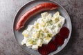 Smoked sausage with potatoes in cream sauce with dill and boiled beets close-up on a plate. Horizontal top view Royalty Free Stock Photo