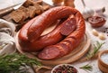 Smoked sausage with rye bread, sauce and garlic on a light background. Royalty Free Stock Photo