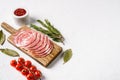Smoked sausage slices, thinly sliced, on white stone table background, with copy space for text Royalty Free Stock Photo
