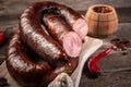 Smoked sausage on a wooden rustic table product from organic farm, produced by traditional methods. Food recipe background. Close Royalty Free Stock Photo