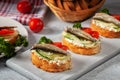 Smoked sprat sandwich - fish fresh cucumber and tomato. Sprat sandwiches on toasted slices of bread