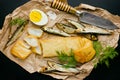 Smoked sprats and squid, boiled egg and fresh dill on paper