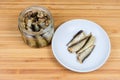 Smoked sprats with vegetable oil in glass jar and saucer Royalty Free Stock Photo