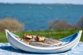 Smoked sprattus or sprats sea fish served outdoor with view on blue sea water