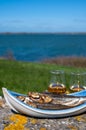 Smoked sprattus or sprats sea fish served outdoor with view on blue sea water