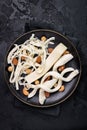 Smoked Traditional Chechil white cheese on a plate with nuts, black background. Royalty Free Stock Photo