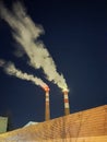 Smokestacks that emit smoke into the night sky, Emit smoke into the environment. Royalty Free Stock Photo