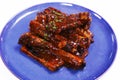 smokey barbeque sauce glazed baby pork ribs in a plate with white background.