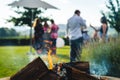 Smokey outdoor fire pit with people gathered together at a party Royalty Free Stock Photo