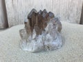 Smokey Quartz on Sand with Wood on Background on the Beach Royalty Free Stock Photo