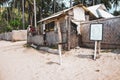 Smoking area on the beach with nameplate with text smoking area and coconut shop with unknown salers. Royalty Free Stock Photo