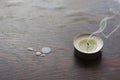 A smoking candle on a wooden table Royalty Free Stock Photo