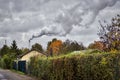 Smoking chimney behind garden plots