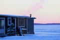 Smoking chimney heating the little ice fishing hut