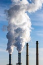 Smoking chimney pipes of a electro power station plant  causing air pollution Royalty Free Stock Photo