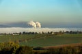 Smoking chimneys in from factory hidden in mist Royalty Free Stock Photo