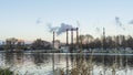 Smoking chimneys of a thermal power plant against a winter cloudy sky. Ecological problems concept. Space for text.