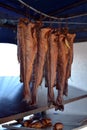 Smoking fish hanging side by side. Cod fish Royalty Free Stock Photo
