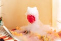 Smoking glass at fruit and vegetable buffet table. Closeup of glass of red beverage with white dense fog. Chemical