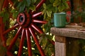 A smoking hot coffee mug on a wooden bench, with an old wooden wagon wheel Royalty Free Stock Photo