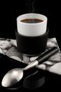 Smoking hot cup of expresso over black background