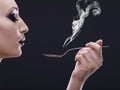 Smoking hot. a young woman holding a spoon and blowing the steam from it. Royalty Free Stock Photo