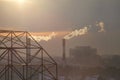 Smoking from industrial chimneys of heating plant emits smoke, smog at sunset in city, pollutants enter atmosphere. Royalty Free Stock Photo