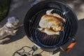 Smoking meat outside - a whole raw chicken with spices sits on the top rack of an open barrel electric smoker with a slab of meat