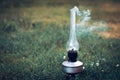 A smoking old kerosene lamp on a green grass. Royalty Free Stock Photo