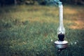 A smoking old kerosene lamp on a green grass. Royalty Free Stock Photo