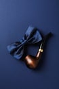 Smoking pipe and tie bow on blue background Royalty Free Stock Photo