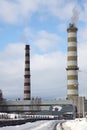 Smoking pipes of heating plant supplying heat to city, power station with three smoke stacks. Royalty Free Stock Photo