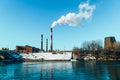 Smoking pipes of the plant against the blue sky, white smoke from the pipes Royalty Free Stock Photo