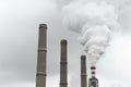 Smoking pipes of thermal power plant with dramatic dark cloudy sky Royalty Free Stock Photo