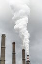 Smoking pipes of thermal power plant with dramatic dark cloudy sky Royalty Free Stock Photo