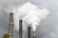 Smoking pipes of thermal power plant with dramatic dark cloudy sky Royalty Free Stock Photo