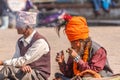 Smoking Sadhu with orange turban at Bhaktapur`s Durbar Square