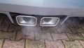 Smoking sports car exhaust outlet Royalty Free Stock Photo