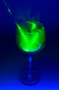 Smoky cocktail with a green laser, on a dark background. Dangerous liquor mixture - close up photo.