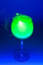 Smoky cocktail with a green laser, on a dark background. Dangerous liquor mixture - close up photo.