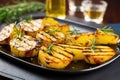 smoky grilled potatoes with fresh rosemary leaves on a table