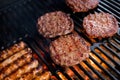 Smoky hamburger meat grilling for burgers. Fry on an open fire on the grill - bbq.Burgers and sausages Cooking Over Royalty Free Stock Photo