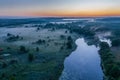 Smoky morning mist over the river. Beautiful panoramic view of river and green banks of the river in the early summer morning Royalty Free Stock Photo