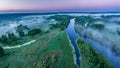 Smoky morning mist over the river. Beautiful panoramic view of river and green banks of the river in the early summer morning Royalty Free Stock Photo