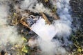 Smoldered book on pile of cut branches in garden Royalty Free Stock Photo