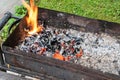 Smoldering coal in an old rusty grill. Preparing for a picnic
