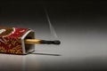 A smoldering match peeking out of a box of smoke. Space for text. Royalty Free Stock Photo