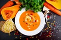 Smooth butternut squash and carrot soup with cream, pumpkin seeds goji berries