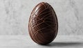 A smooth, chocolate egg standing upright, adorned with an intricate web of fine,